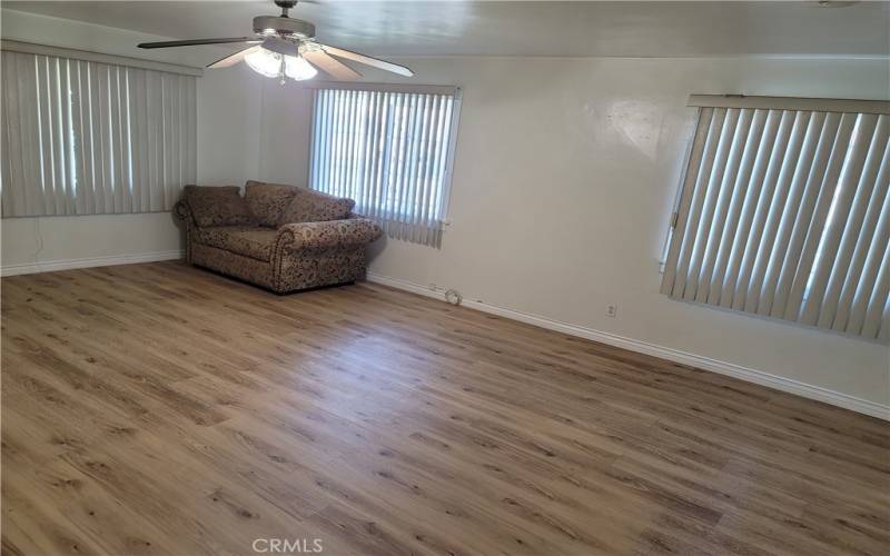 Spacious living room with matching fine flooring and three large window.