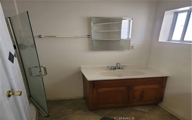 Master bedrooms bathroom sink, with shower and toilet to side of pic.