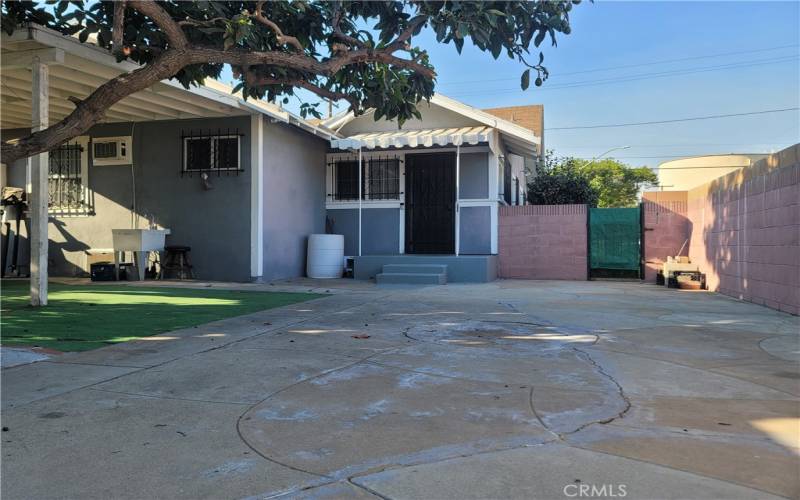 Back yard picture facing the property. Plenty of shade and concrete floor keep things clean. There is more space to the left of this picture giving a more open backyard.