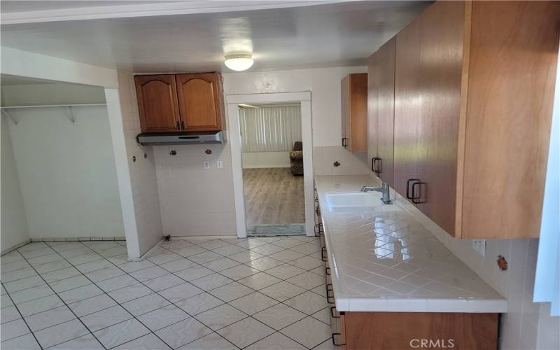 Specious and elegant kitchen with entrance to living room. Quality classic tile counter tops and flooring.