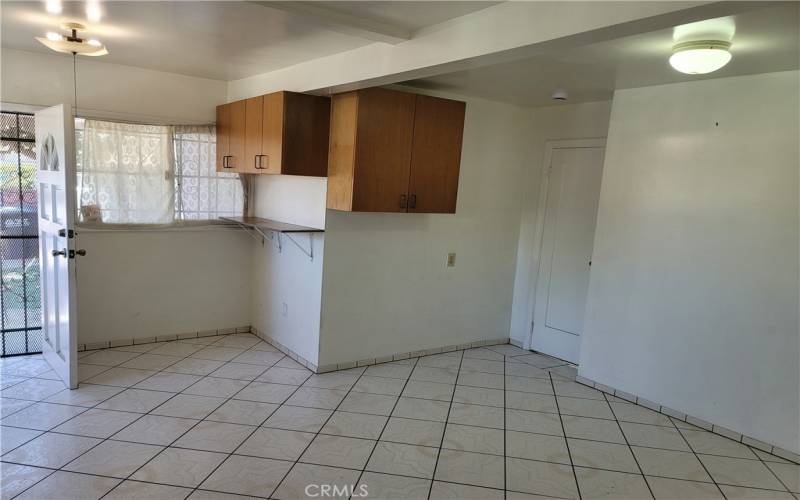 Spacious elegant kitchen back window and door with cabinets and quality tile flooring.