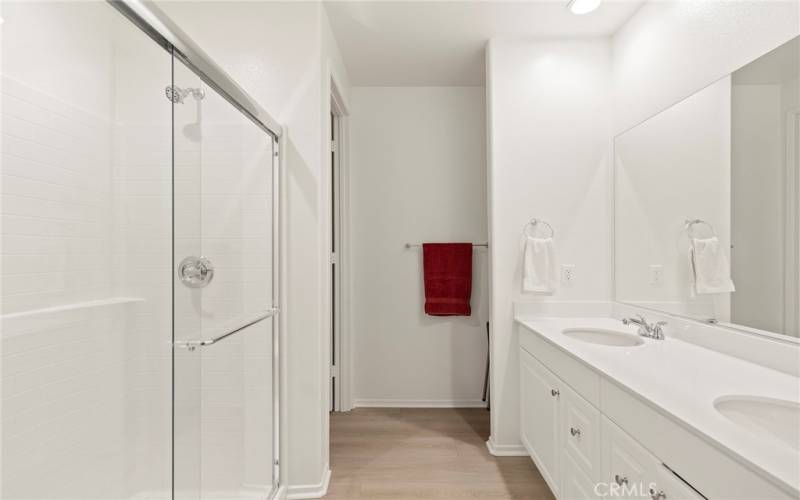 Primary bathroom with dual vanity and walk in shower