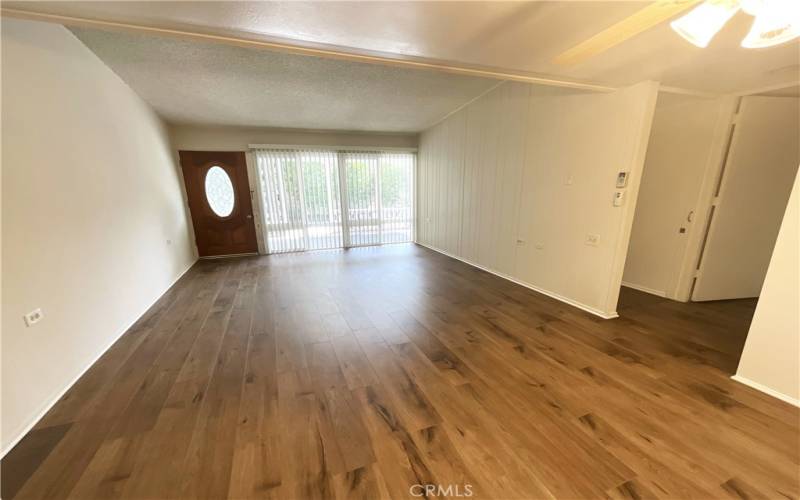 Living room overlooks the outdoor patio...custom wood entry door...attractive wood laminate flooring~