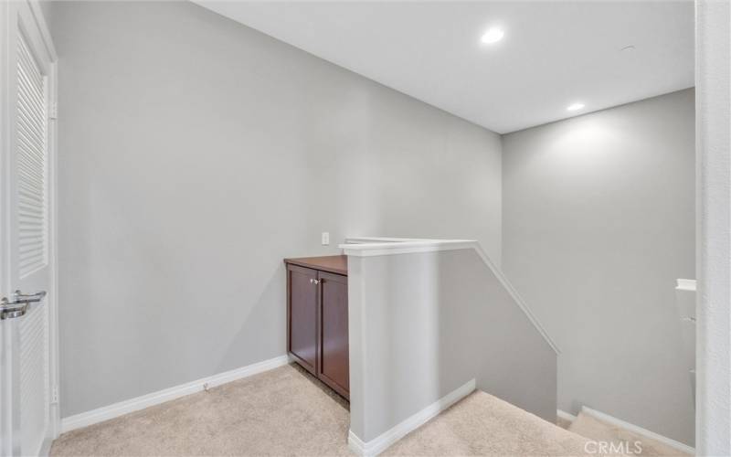 Upstairs landing with linen cabinet and laundry area