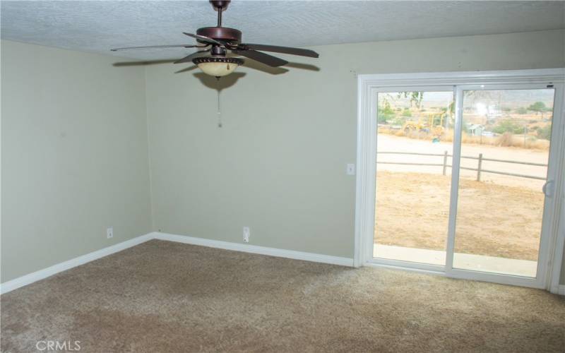 Primary bedroom with ceiling fan, slider to rear yard. and on suite bath