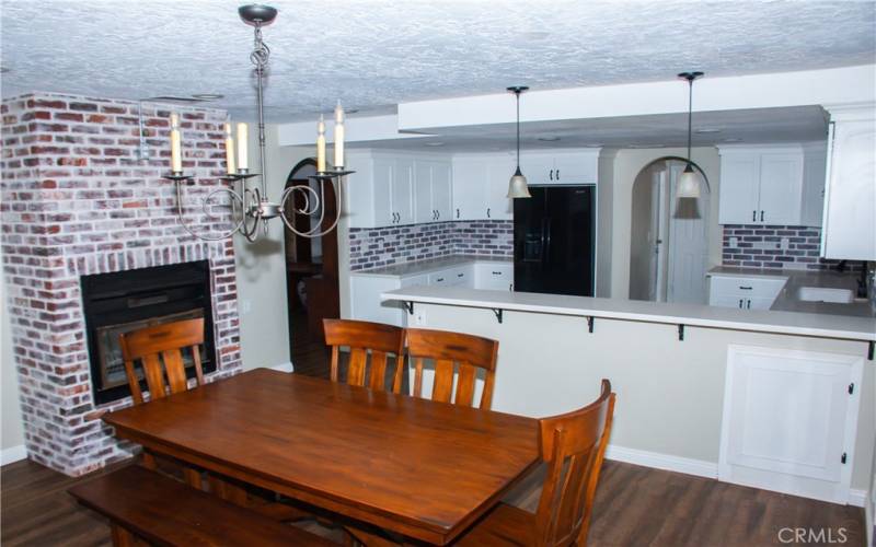 Kitchen with Quartz counters, modern white cabinets, custom backsplash, breakfast bar and stainless/black appliances.