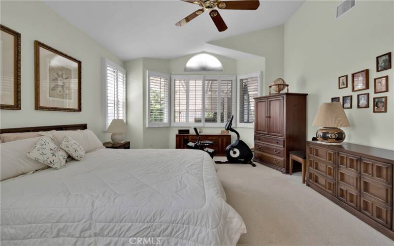 Primary bedroom with window shutters