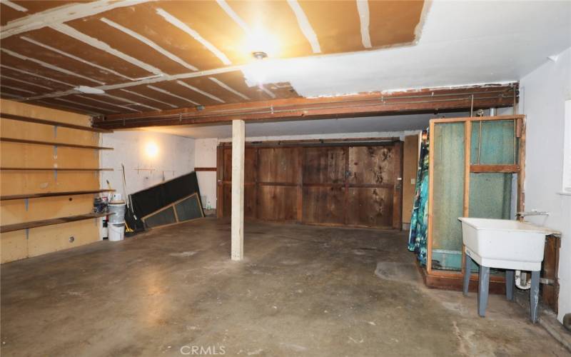 Garage with washer and dryer hook ups and stall shower.