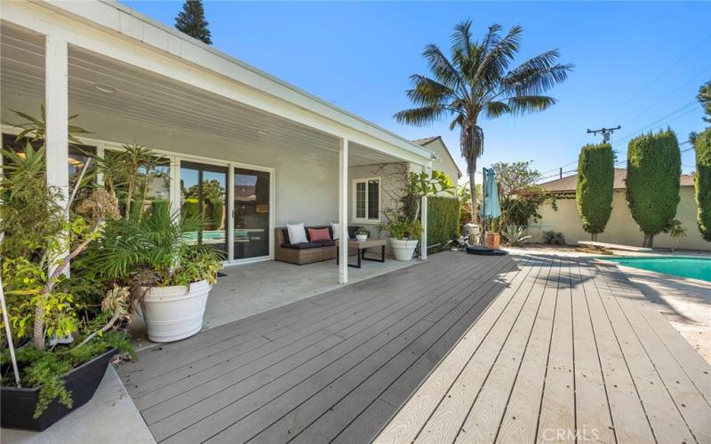 Covered back porch is a great place to relax and keep cool after a swim in the pool.