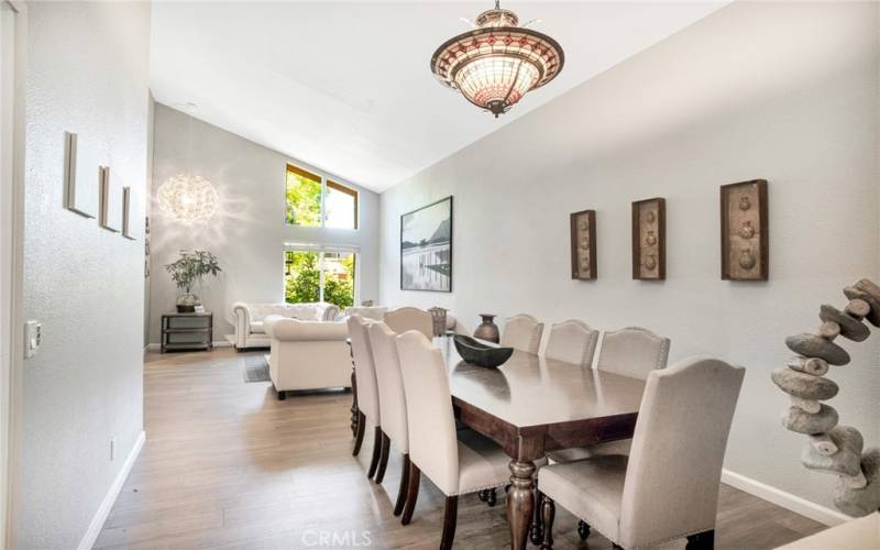 The formal dining room with its pitched ceiling, designer drop-down lighting, and glistening wood laminate floors can easily accommodate large gatherings.