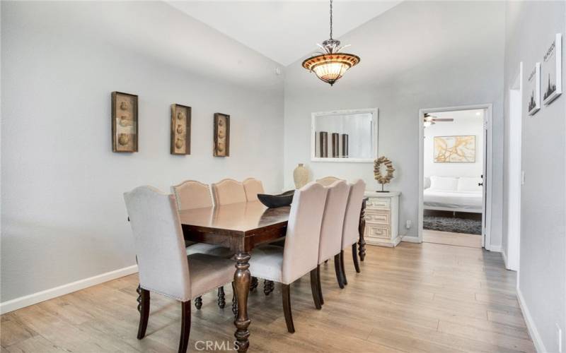 The formal dining room with its pitched ceiling, designer drop-down lighting, and glistening wood laminate floors can easily accommodate large gatherings.