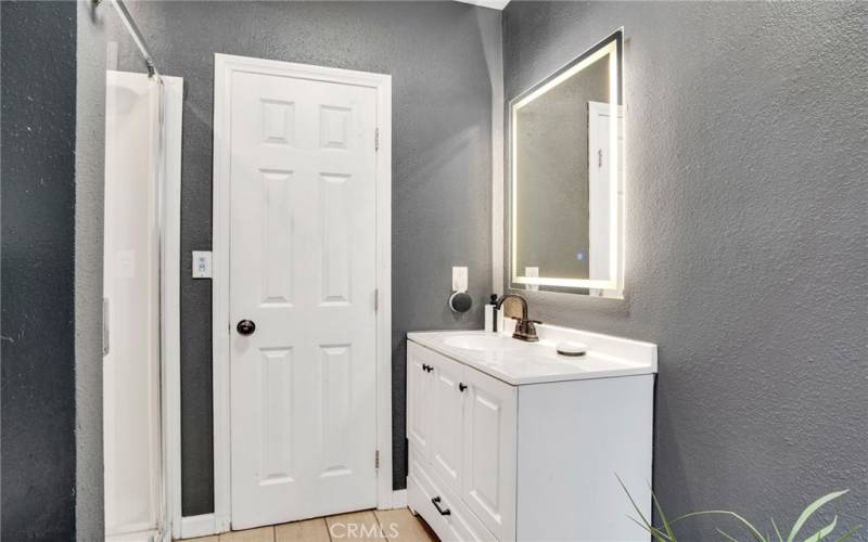 2 downstairs junior primary suites with sparkling windows, lighted ceiling fans, private entries (one offers access to the backyard); plus, private en suite bathrooms with white vanities, undermount basins, touch screen back-lit mirrors and tile floors.