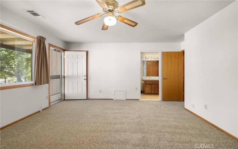 Second Primary Bedroom with door to back patio.  Walk in Closet is behind the open white door.