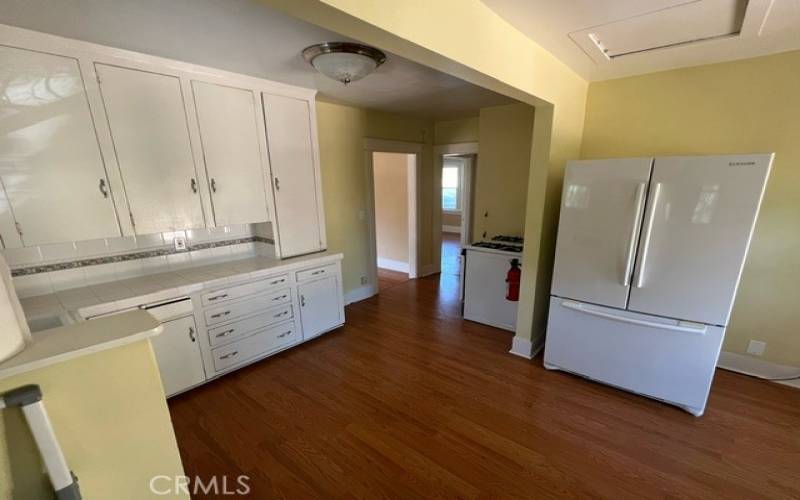 Large kitchen with refrigerator and gas range.
