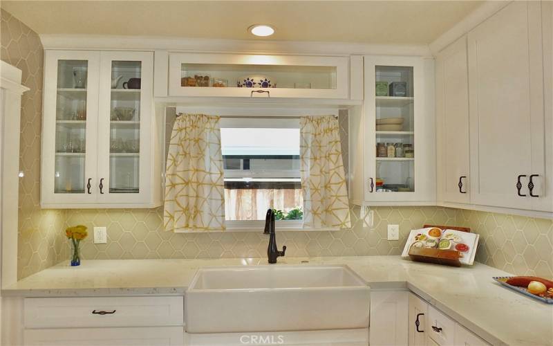 View of elegant cabinetry with glass doors, perfect for showcasing your favorite dishes and platters.