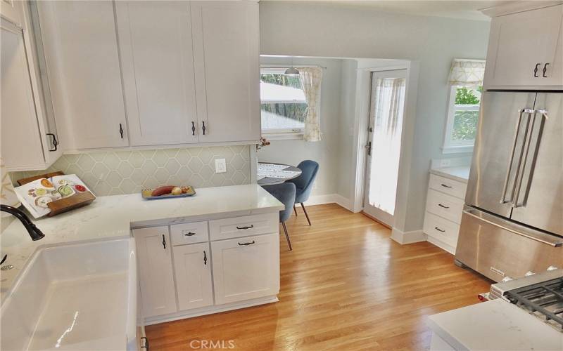 Another look at this fabulous kitchen, complete with a French door refrigerator, soft-close drawers and cabinets, and a cozy dining area that offers a charming view of the backyard.

