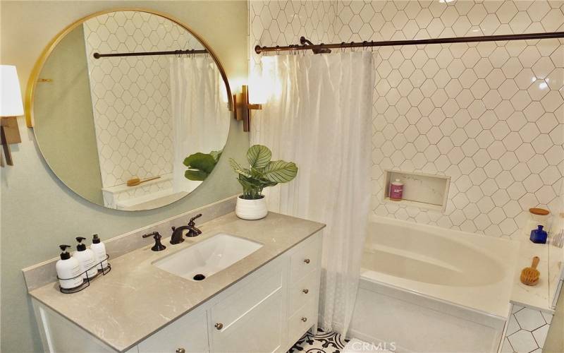 Fully remodeled bathroom featuring a luxurious soaking tub and shower combination, along with ample storage