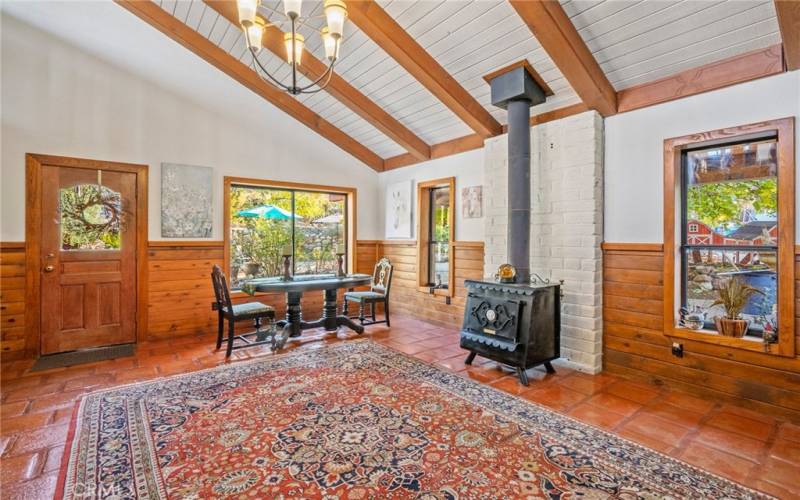 Living room next to kitchen with wood-burning fireplace