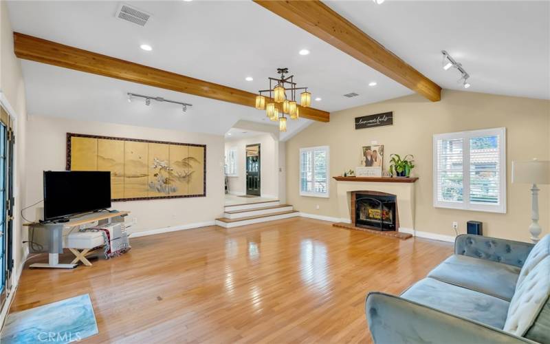 Step-down family room from the kitchen with beamed ceiling, and track and recessed lighting.