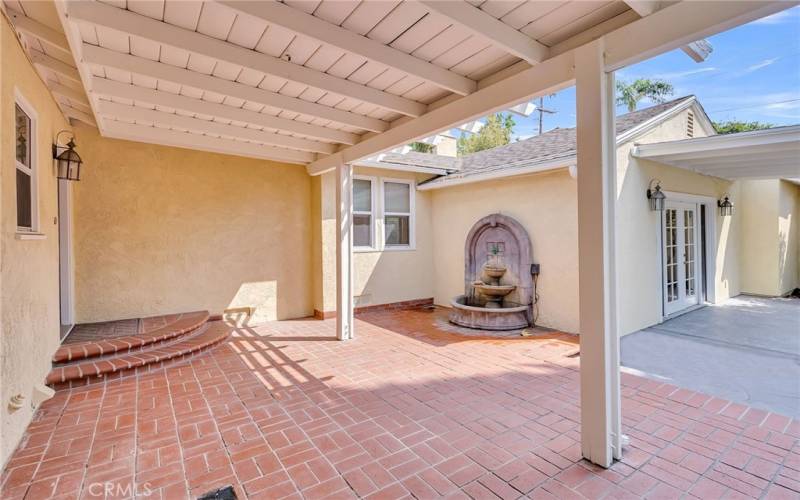 Covered patio with view of fountain (windows to left of fountain are in the kitchen informal dining area).