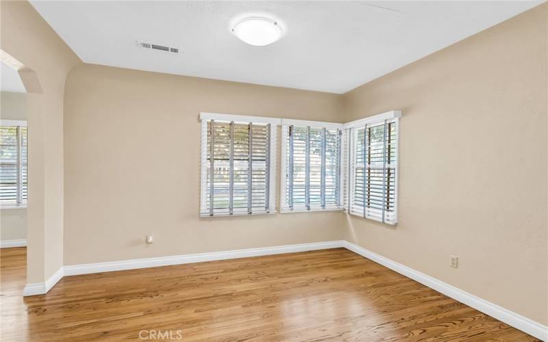 Formal dining room with hardwood flooring and lots of natural light.