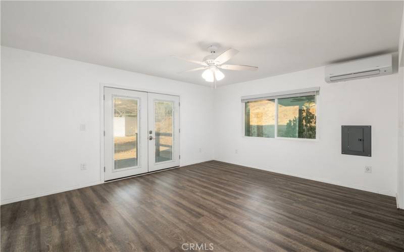 Primary bedroom with double doors leading to small deck off the back of the house