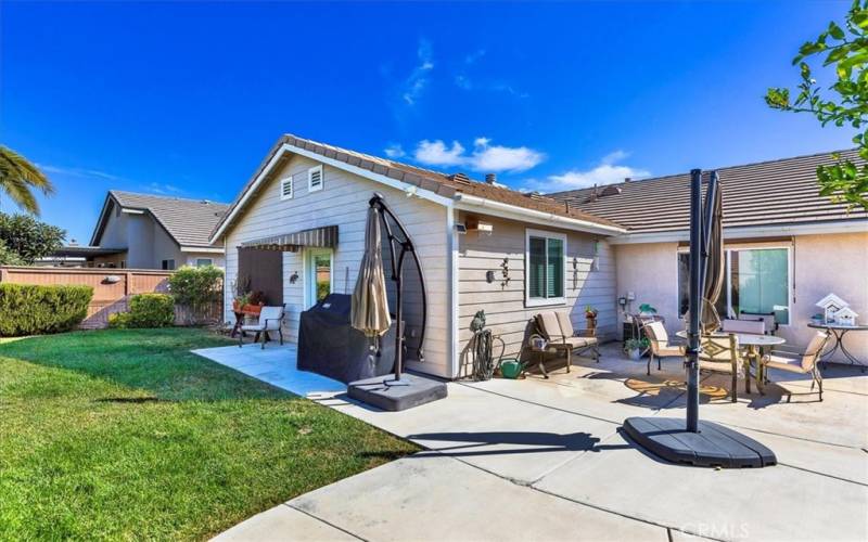 Spacious back yard with patio and lawn area.