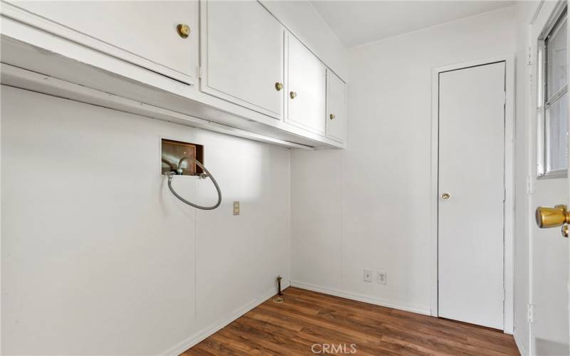 Designated laundry room with extra cabinet storage.