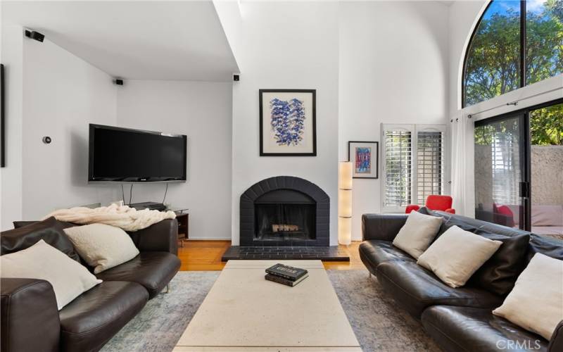 Living room with wood-burning fireplace and slider leading to front patio.