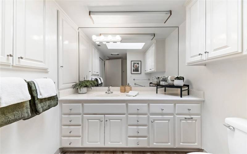 Bathroom With An Abundance of Daylight From the Skylght & Crisp White Cabinets