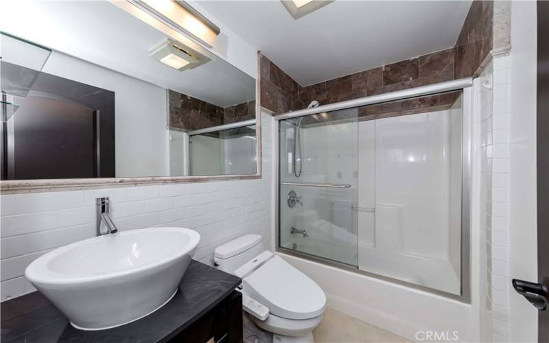 Upstairs Full Hall Bath w Stone Surrounds & Flooring, Bidet Toilet and Modern Vessel & Fixtures.