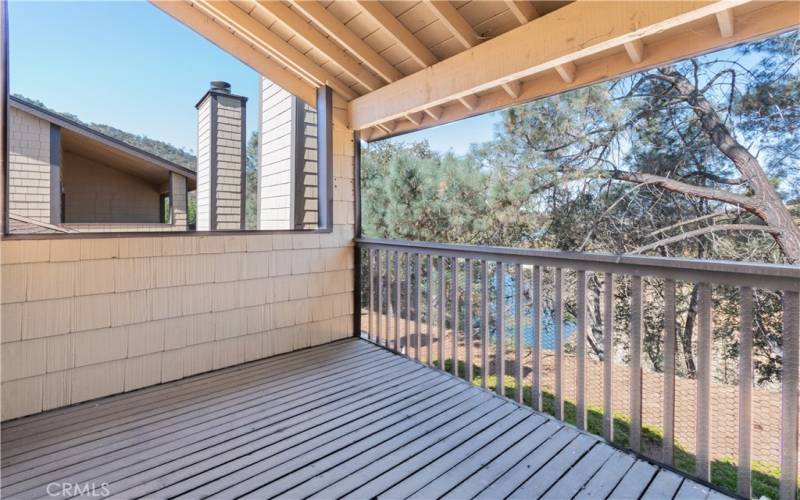 Primary bedroom includes this covered deck with lake views