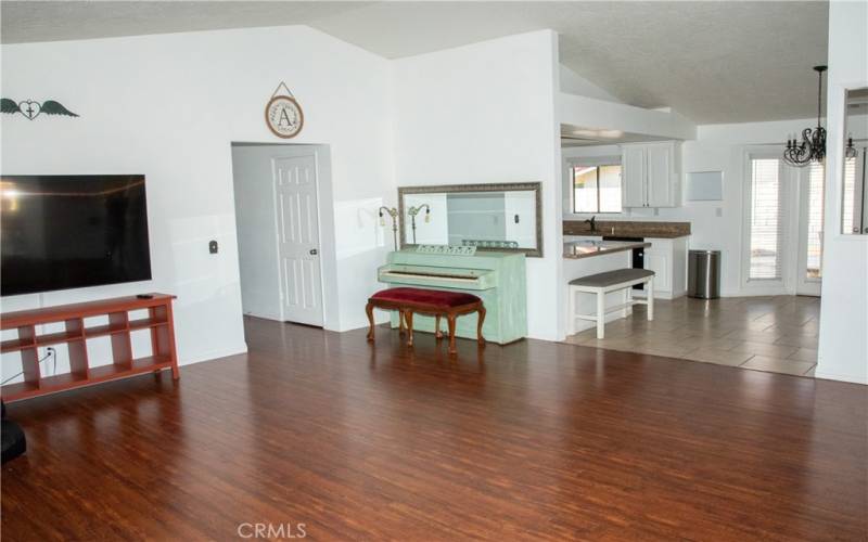 Living room showing fireplace with brick and custom wood facade in addition to laminate wood flooring and new paint.