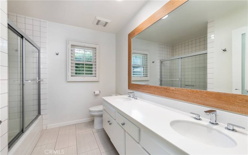 Second bathroom with shower/bathtub and dual sinks.