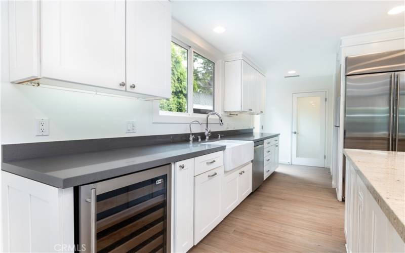 Kitchen, custom fixtures, wine fridge, grey stone countertops.