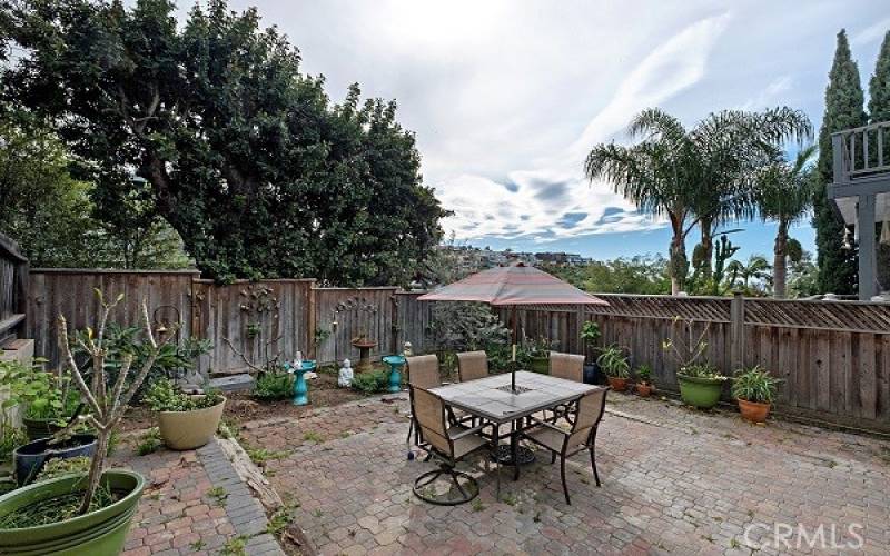 Large private outdoor rear patio surrounded with mature trees