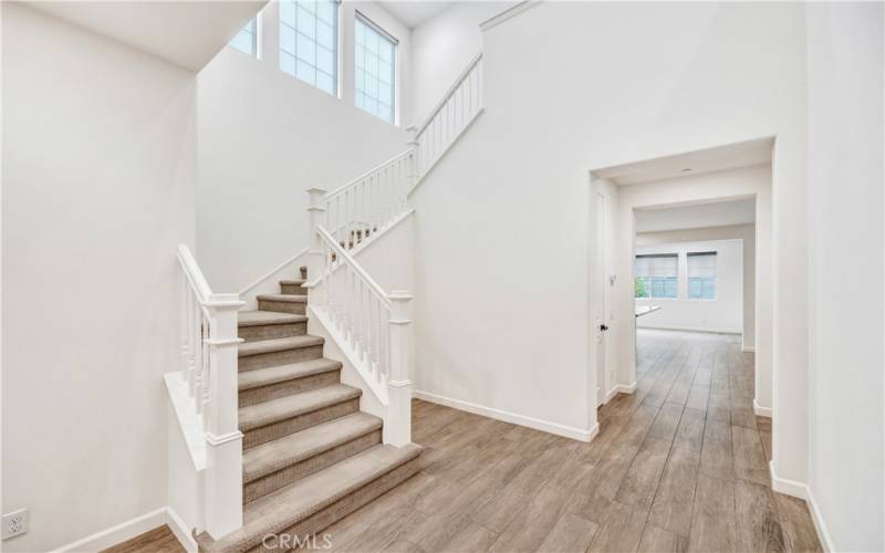 Front entry with wide plank wood looking tile flooring.