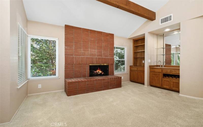 Primary suite fireplace, built-ins, and wet bar