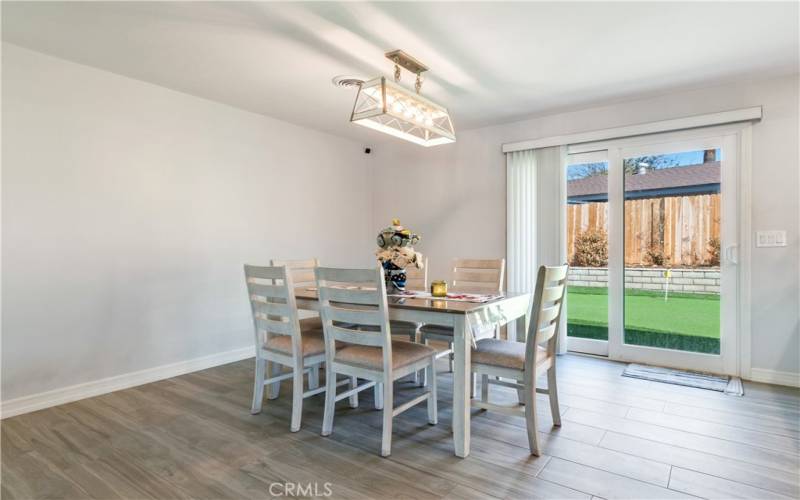 This is a view of the dining room, where you can see the backyard sliding door and the windows. The dining room is spacious and has a lot of natural light.