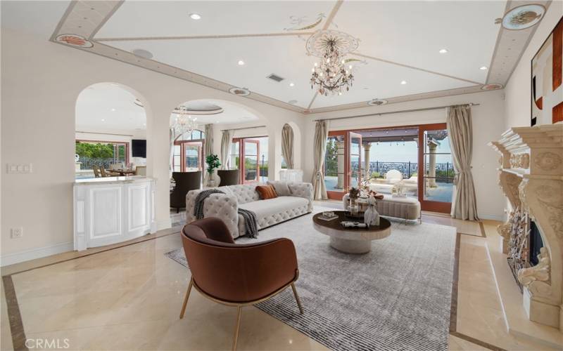 Living room with fireplace overlooking pool, city and ocean views.