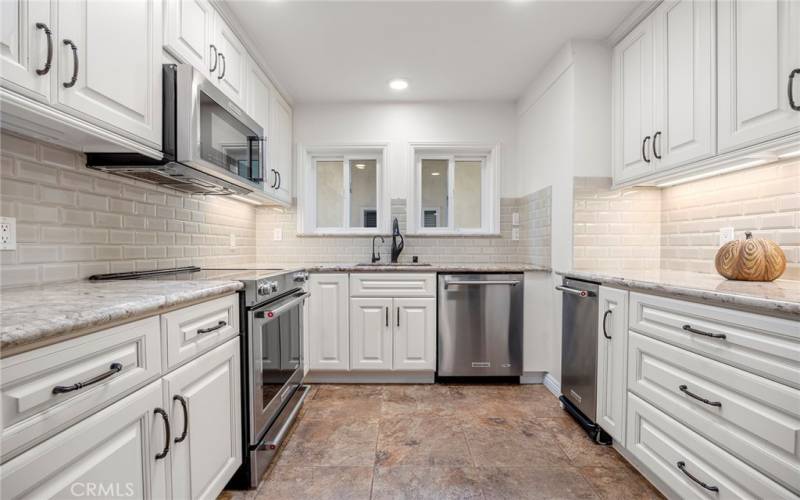 UPGRADED KITCHEN WITH MANY CABINET PULL OUT SHELVES, GRANITE COUNTERS, KITCHEN AID APPLIANCES INCLUDING THREE DOOR REFRIGERATOR