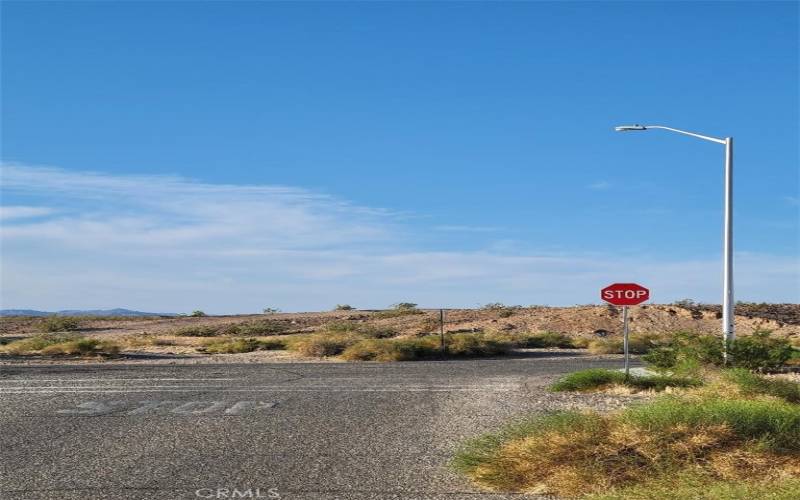 Paved street, sidewalk, and street lights on north boundary.