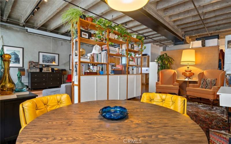 Dining table area with book shelf separating living room