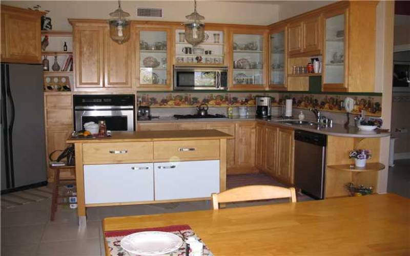 Kitchen, eating area.  Large pantry (not shown) door to garage left of refrigerator. Gas cook top. Elec oven. Free standing island for ease of entertaining.