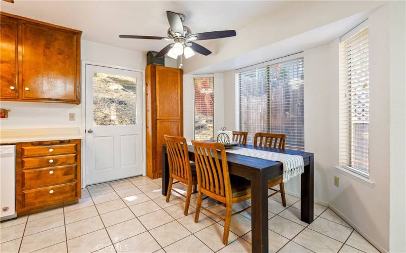 The dining area is highlighted by the bay window, ceiling fan and door that leads to the backyard.