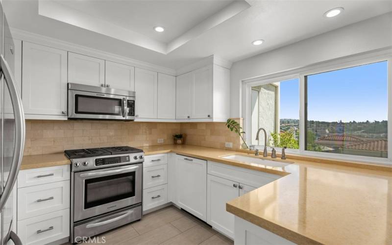 Upgraded kitchen with stainless steel suite of appliances, granite counters, and lake views.