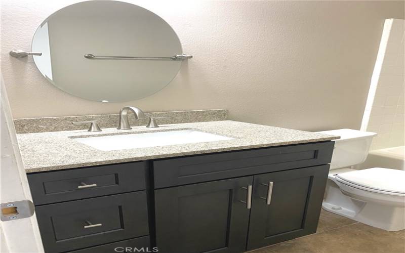 Primary bath that has a tub with shower, upgraded sink, vanity and modern faucets.