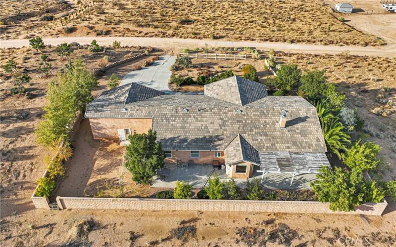 Like a true oasis. The fruit trees and lush landscape hugs the house and provides green views inside the house as well as a breeze break.