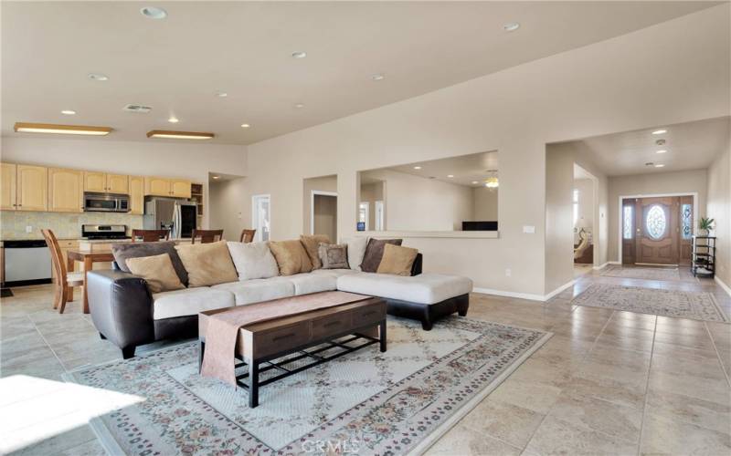 Open floorplan with vaulted ceilings, custom tile and wood cabinetry. The granite counters have beveled edge and are paired with a full height tumbled stone backsplash.