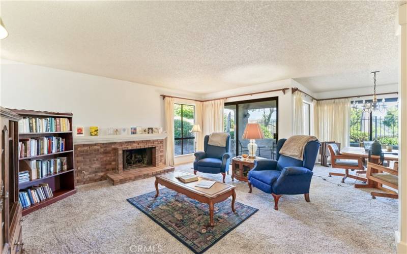 Living room with fireplace leading to patio